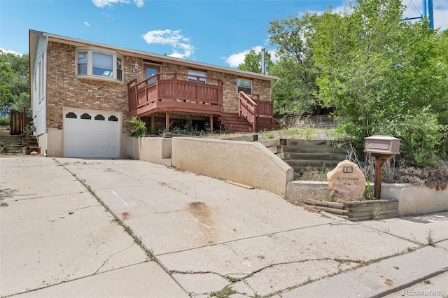 18 Clover Cir, Colorado Springs, CO 80906 - view of front of house with brick siding, a garage, driveway, a deck, and stairs