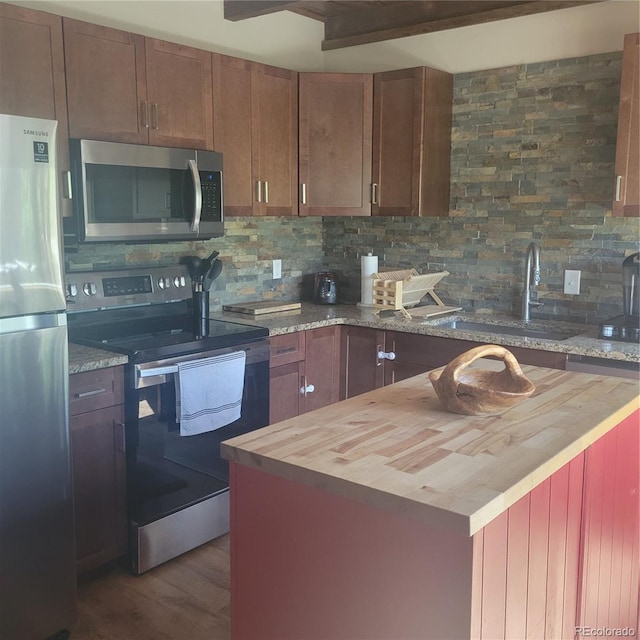 1034 Van Fossan Ln, Fort Garland, CO 81133 - kitchen with stainless steel appliances, wood counters, backsplash, a sink, and beamed ceiling