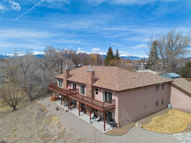 121 M And M Ln Unit 6C, Salida, CO 81201 - rear view of house featuring a deck with mountain view, stucco siding, a patio area, and a chimney