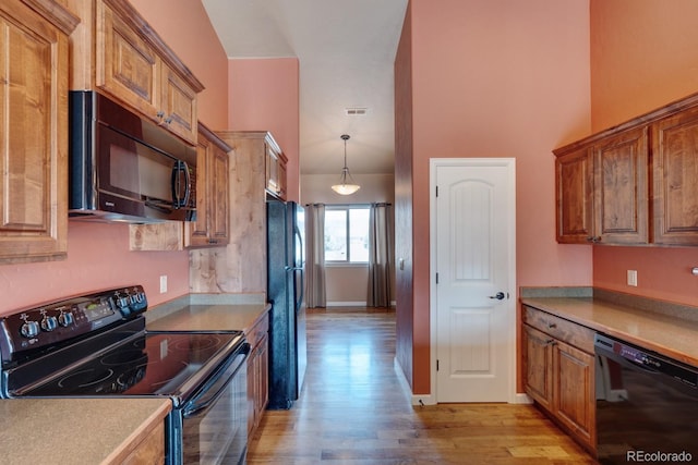 121 M And M Ln Unit 6C, Salida, CO 81201 - kitchen featuring light countertops, hanging light fixtures, brown cabinets, black appliances, and light wood-style floors