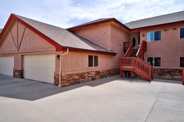 121 M And M Ln Unit 6C, Salida, CO 81201 - view of front facade featuring stairs, driveway, stone siding, stucco siding, and a garage