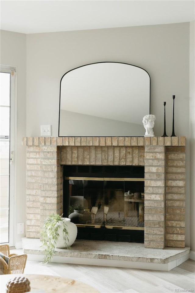 interior details featuring a brick fireplace and hardwood / wood-style floors