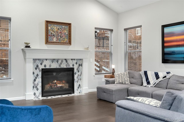 living room featuring a fireplace, dark hardwood / wood-style floors, a healthy amount of sunlight, and vaulted ceiling