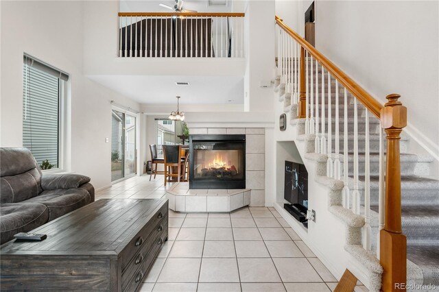20835 E 47th Ave, Denver, CO 80249 - living room featuring a fireplace, a towering ceiling, stairs, and light tile patterned floors