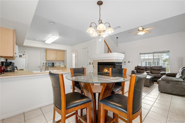 20835 E 47th Ave, Denver, CO 80249 - dining room featuring light tile patterned floors, visible vents, a fireplace, and ceiling fan with notable chandelier