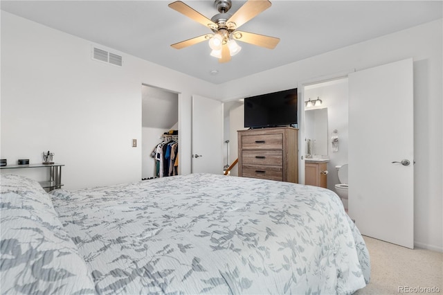 20835 E 47th Ave, Denver, CO 80249 - bedroom featuring a ceiling fan, visible vents, connected bathroom, a walk in closet, and light carpet