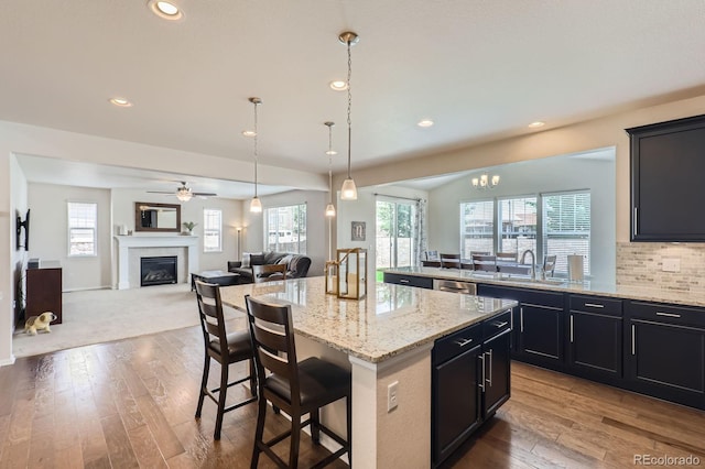 12578 Hudson Ct, Thornton, CO 80241 - kitchen with open floor plan, a breakfast bar area, hardwood / wood-style floors, a center island, and recessed lighting