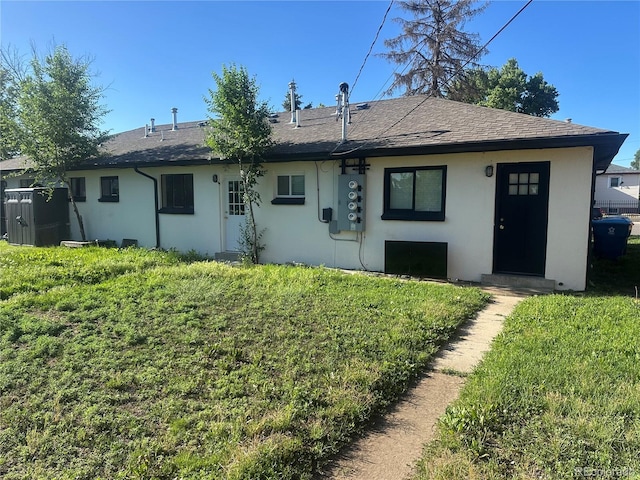 6671 E 73rd Pl, Commerce City, CO 80022 - rear view of house with stucco siding, a lawn, and a shingled roof