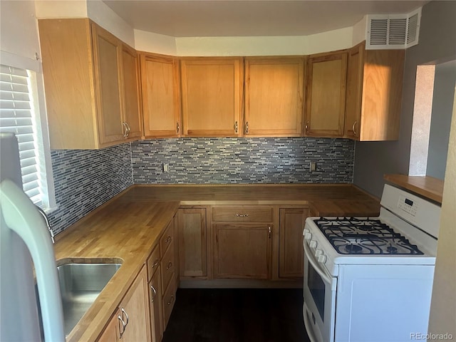6671 E 73rd Pl, Commerce City, CO 80022 - kitchen featuring white gas stove, butcher block countertops, backsplash, and brown cabinets
