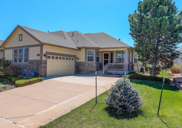 view of front of home with central air condition unit, stone siding, a front lawn, a porch, and a garage