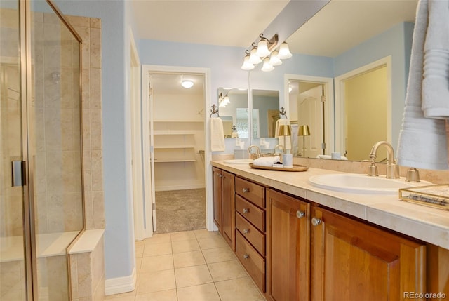bathroom featuring a shower stall, tile patterned floors, double vanity, and a sink
