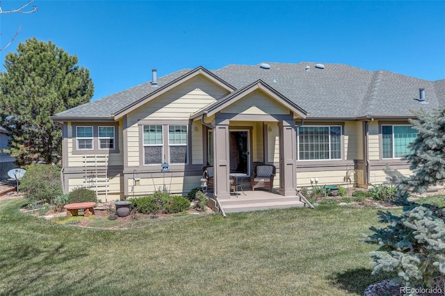 view of front of home featuring a shingled roof and a front yard