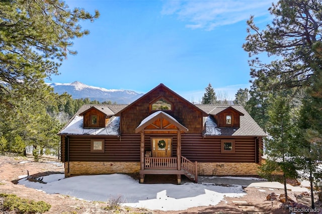 log cabin featuring stone siding and a mountain view