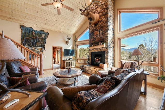 living area featuring light wood-style floors, a ceiling fan, wood ceiling, high vaulted ceiling, and stairs