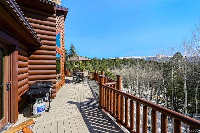 wooden deck with outdoor dining area and a mountain view