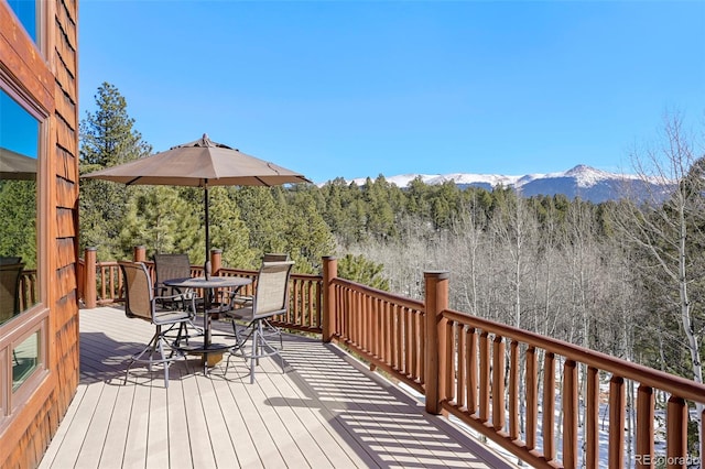 wooden terrace featuring outdoor dining space and a mountain view