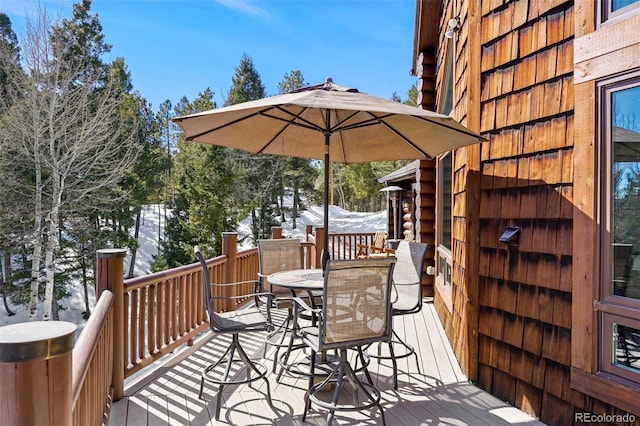 snow covered deck featuring outdoor dining space