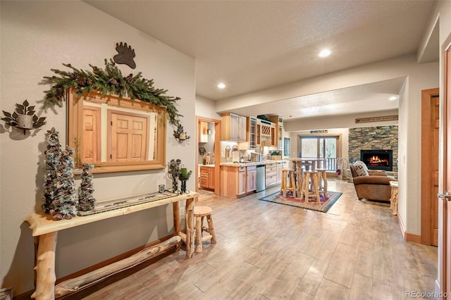 interior space with recessed lighting, a fireplace, a textured ceiling, and light wood finished floors