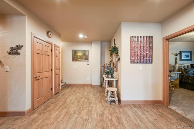 hall with light wood finished floors and baseboards