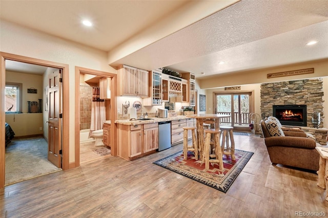 kitchen featuring glass insert cabinets, light countertops, light wood-style floors, and light brown cabinets