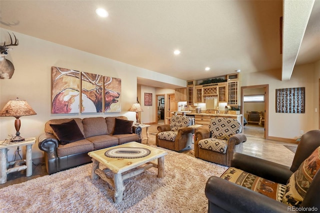 living area featuring baseboards, wood finished floors, and recessed lighting