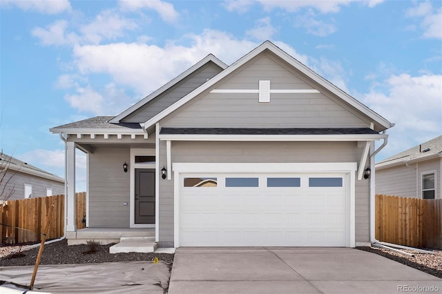 view of front of house featuring fence, a shingled roof, a garage, and concrete driveway
