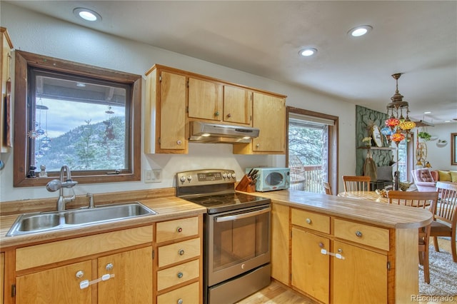 kitchen featuring stainless steel electric range, pendant lighting, sink, kitchen peninsula, and light hardwood / wood-style flooring