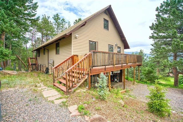 rear view of property featuring a wooden deck