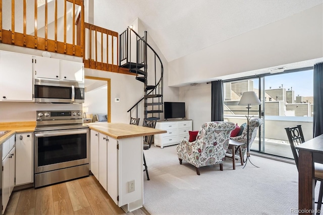 5250 S Huron Way Unit 5-308, Littleton, CO 80120 - kitchen featuring appliances with stainless steel finishes, white cabinetry, light countertops, light wood-type flooring, and a peninsula