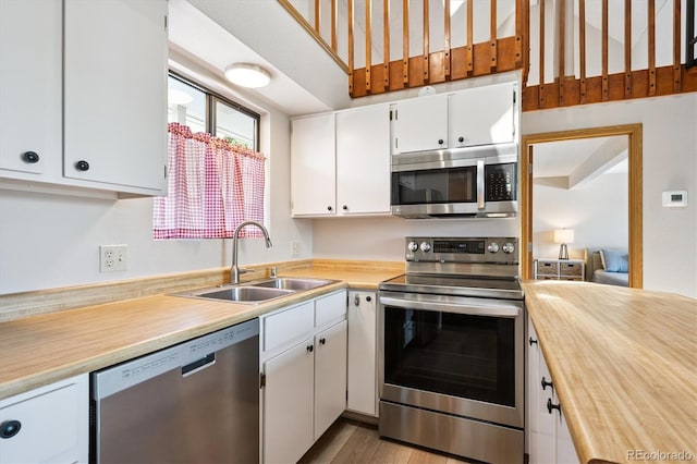 5250 S Huron Way Unit 5-308, Littleton, CO 80120 - kitchen featuring stainless steel appliances, white cabinets, wood finished floors, and butcher block counters