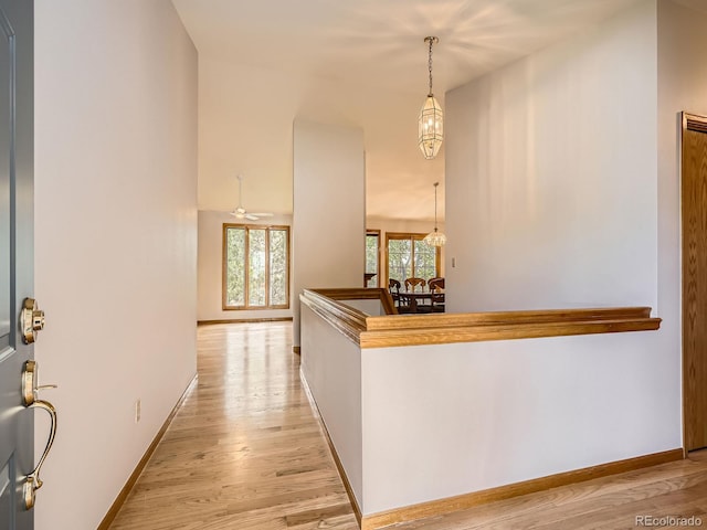 9670 W 69th Ave, Arvada, CO 80004 - hallway featuring light wood-style flooring, baseboards, and a chandelier