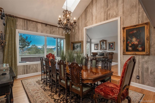 1854 Foothills Dr S, Golden, CO 80401 - dining room featuring vaulted ceiling with skylight, a notable chandelier, baseboards, and light wood finished floors