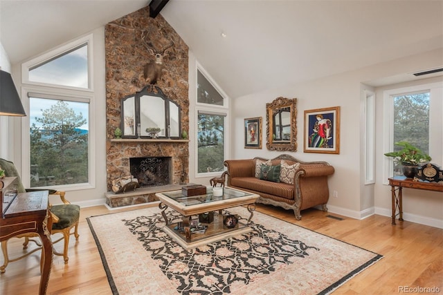 1854 Foothills Dr S, Golden, CO 80401 - living area featuring beamed ceiling, light wood finished floors, a fireplace, and a healthy amount of sunlight
