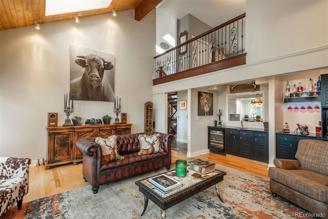 1854 Foothills Dr S, Golden, CO 80401 - living room featuring baseboards, beamed ceiling, wine cooler, high vaulted ceiling, and light wood finished floors