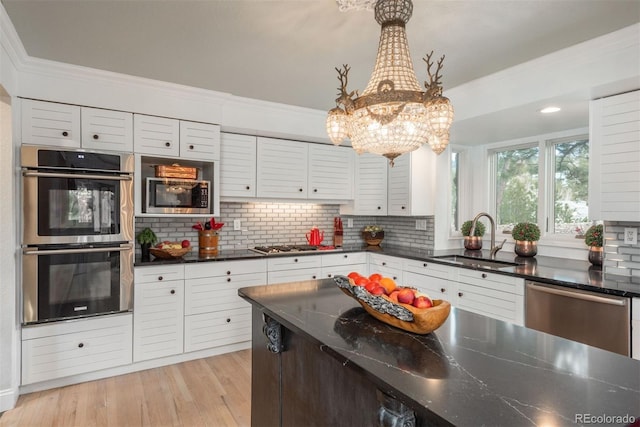1854 Foothills Dr S, Golden, CO 80401 - kitchen featuring white cabinets, a sink, appliances with stainless steel finishes, crown molding, and decorative backsplash
