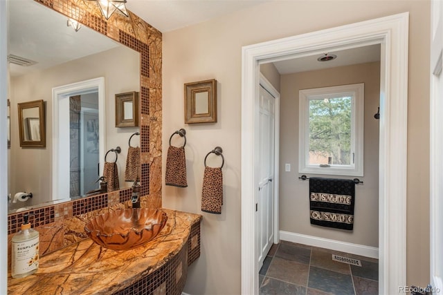 1854 Foothills Dr S, Golden, CO 80401 - bathroom with stone finish floor, visible vents, baseboards, and backsplash