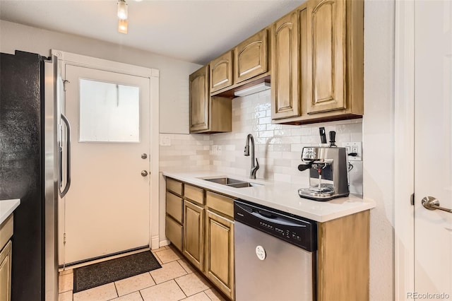 kitchen with tasteful backsplash, light tile patterned flooring, appliances with stainless steel finishes, and sink