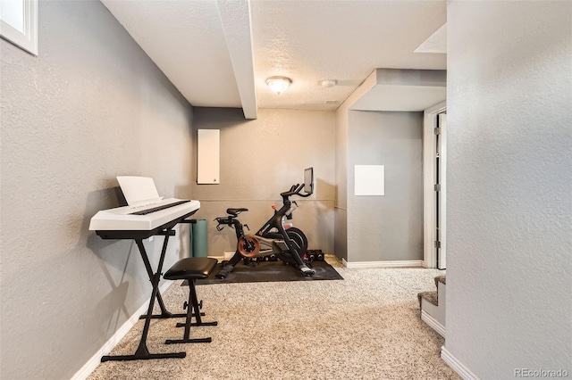 workout room featuring carpet and a textured ceiling