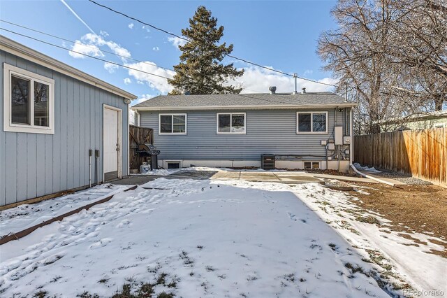 snow covered back of property with central AC unit