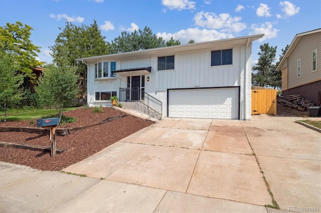 13051 W Jewell Cir, Lakewood, CO 80228 - raised ranch featuring an attached garage, driveway, and brick siding