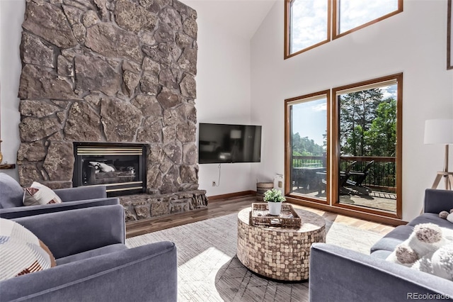 20223 Goins Dr, Morrison, CO 80465 - living room featuring high vaulted ceiling, a stone fireplace, and wood finished floors