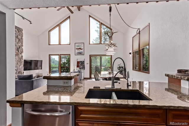 20223 Goins Dr, Morrison, CO 80465 - kitchen with dishwasher, stone countertops, open floor plan, high vaulted ceiling, and brown cabinets