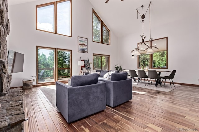 20223 Goins Dr, Morrison, CO 80465 - living area featuring high vaulted ceiling, wood finished floors, and a chandelier