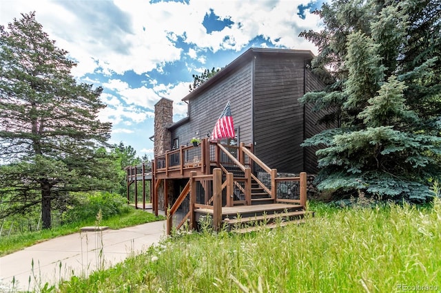 20223 Goins Dr, Morrison, CO 80465 - rear view of property with a wooden deck, a chimney, stairs, and driveway