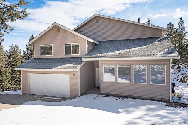 traditional-style home with a garage and a shingled roof