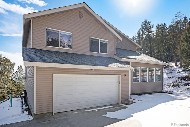 view of front of property with an attached garage and roof with shingles