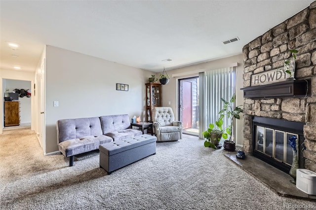 carpeted living area with visible vents and a stone fireplace