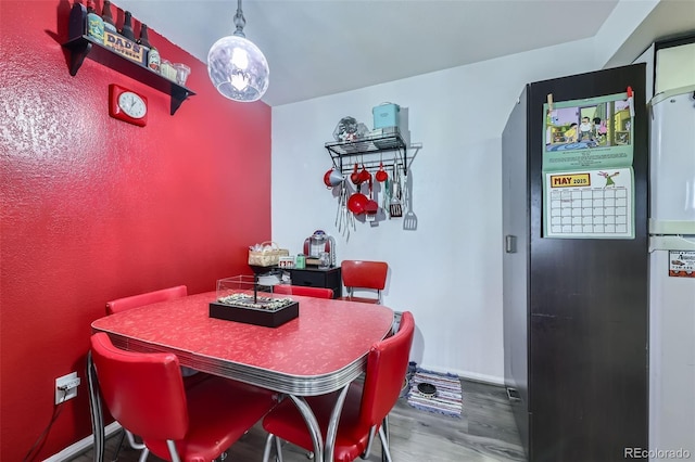 dining area featuring wood finished floors and baseboards