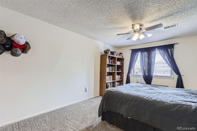 bedroom featuring a textured ceiling, carpet, baseboards, ceiling fan, and visible vents