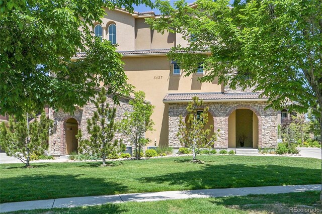 3437 Rosato Dr Unit C, Highlands Ranch, CO 80126 - mediterranean / spanish-style home featuring stone siding, stucco siding, and a front lawn
